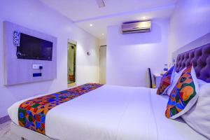 孟买FabExpress Embassy Suites的卧室配有一张白色大床和电视。