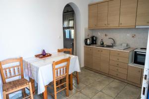 帕罗斯岛Afroditi studios的厨房配有桌椅和水槽。