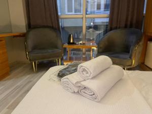 KonakDNC REZİDANCE的两条毛巾,放置在床上,配有两把椅子