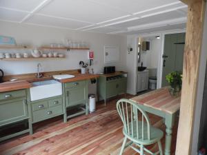 NewchurchNewchurch Nook的铺有木地板的厨房配有绿色橱柜