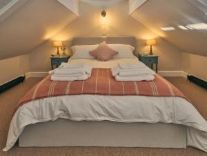 AshingtonThe Pump House的一间卧室配有一张大床和毛巾
