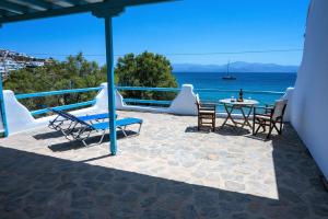 帕罗斯岛Afroditi studios的一个带桌椅的庭院和大海