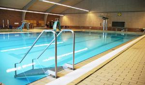ÅrreHelle Aktivitetshotel的健身房内的一个蓝色海水大型游泳池
