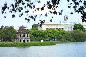 河内Sword lake hostel的一座建筑,位于湖边,建筑背景