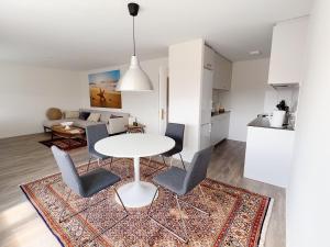 韦齐孔Moderne & helle Wohnung mit Netflix & Bergsicht的厨房以及带白色桌椅的起居室。