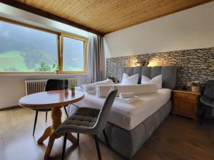 施图拜河谷新施蒂夫特Pension Terra的一间卧室配有一张床、一张桌子和一个窗户。
