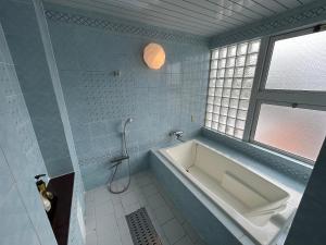 京都Hotel Sunday Brunch (Adult Only)的带浴缸的浴室和窗户。