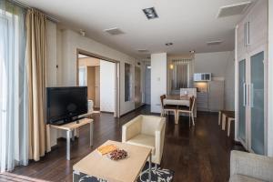 蒂豪尼回声公寓全套房酒店 的客厅配有平面电视和沙发。