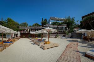 卡萨米尔HOTEL DENOEL的海滩上的一组躺椅和遮阳伞