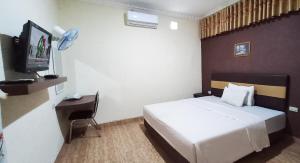MetroGrand S'kuntum Hotel Syariah的一间酒店客房,配有一张床和一台电视