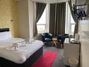 布莱克浦South Beach Hotel的酒店客房,配有一张床和两把椅子