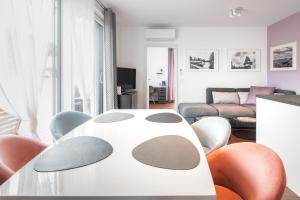 格拉茨Kaiser Apartments - Wohnpark Graz-Gösting的客厅配有白色的桌子和椅子