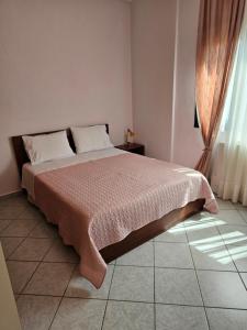 特里卡拉Pallantza Estate Trikala的一间卧室配有一张带粉色毯子的床