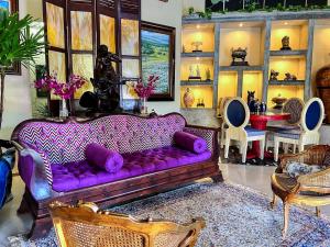 埃尔巴列德安通Casa Madre Tierra的客厅配有紫色沙发和一些椅子