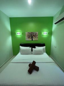 珍南海滩Sandy Beach Resort By Casa Loma的一间绿色卧室,配有一张横跨床