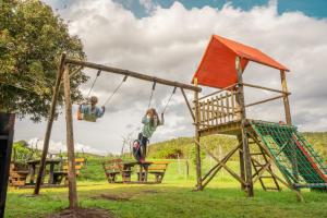 SwanepoelskraalAfriCamps Addo的两个孩子在公园里玩秋千