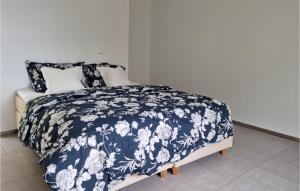 曼达尔Beautiful Apartment In Mandal With House Sea View的一张带蓝色和白色棉被和枕头的床
