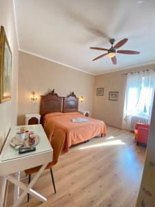 佛罗伦萨达利酒店的一间卧室配有一张床、一张桌子和吊扇
