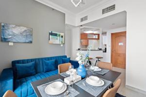 迪拜StoneTree - Stylish 1BR near Marina Walk的客厅配有蓝色的沙发和桌子