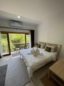 他朗Luancharoen Home Resort Phuket的一间卧室,配有一张带鲜花的床