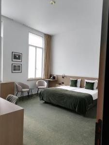 科特赖克梅塞恩酒店的一间卧室设有一张大床和一个窗户。
