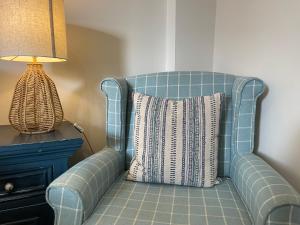 布赖特灵西The Courtyard Rooms的灯边带枕头的蓝色椅子