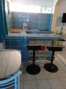 MatouryStudio proche aéroport 2perswifi的厨房在柜台前设有两个吧台凳