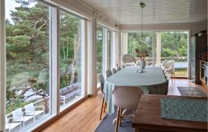 格里姆斯塔Cozy Home In Grimstad With House Sea View的一间设有大窗户和桌椅的用餐室