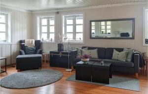 格里姆斯塔Cozy Home In Grimstad With House Sea View的客厅配有沙发、椅子和镜子