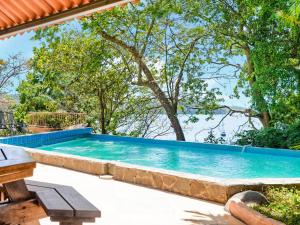 博卡奇卡Villas at Gone Fishing Panamá Resort的一座大游泳池,位于一个树木繁茂的庭院内