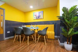 考文垂A103 Cosy City Loft的用餐室设有黄色的墙壁和桌椅