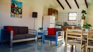 奥拉涅斯塔德Talk of the Town Inn & Suites - St Eustatius的厨房配有沙发、椅子和桌子