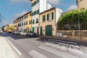 佛罗伦萨Boboli Gardens Lovely Apartment的街道上,有汽车停在建筑前