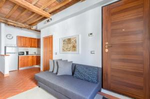 佛罗伦萨Boboli Gardens Lovely Apartment的带沙发和木门的客厅