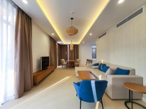 芽庄Luxury villa trong Whyndham garden Cam Ranh的客厅配有白色沙发和蓝色椅子