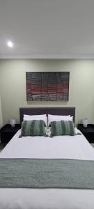 韦尔科姆Uitsig Boutique Hotel的卧室配有一张带两个枕头的大白色床