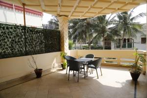 卡拉奇Waypoint Hotel的一个带桌椅和棕榈树的庭院