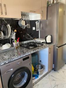 塞拉Bel appart said hajji的厨房配有洗衣机和冰箱。