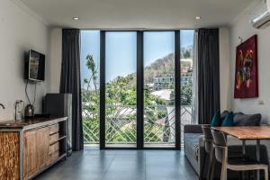 纳闽巴霍Komodo Suites Downtown Managed by CPM Bali的带沙发和大窗户的客厅