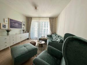 贝尔格莱德SuprStay - Belgrade Waterfront Luxury Apartment的客厅配有绿色沙发和椅子