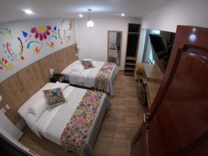 阿亚库乔Platero Hotel的酒店客房设有两张床和钢琴