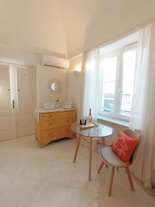 阿纳卡普里L'Archetto romantic suite in the center of Anacapri的客房设有桌子、椅子和窗户。