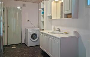 法尔松4 Bedroom Amazing Home In Farsund的一间带洗衣机和水槽的浴室