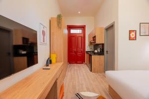 开罗Brassbell studios in Zamalek的一间带红色门的客厅和一间厨房