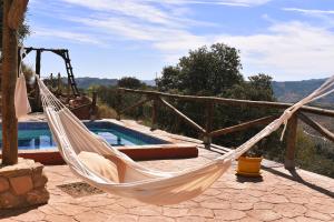 马拉加Casa KiSi Cottage, Rural Boutique Bed & Breakfast的游泳池旁天井上的吊床