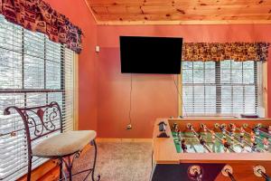 加特林堡Cozy Cub Cabin的客厅配有桌子和墙上的电视