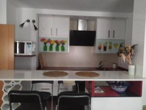 埃希哈Apartamento Centro Écija的厨房配有白色的柜台和椅子
