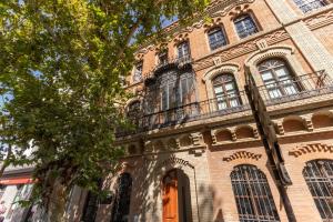 塞维利亚Charming 2 Bedroom Apartment at Sevilla City Center By Cityzen的一座带窗户和阳台的大型砖砌建筑