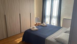 龙基德伊莱焦纳里Rose e Frutta ristrutturato con parcheggio的一间卧室配有蓝色的床和白色椅子