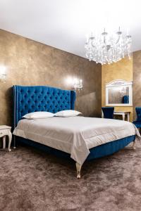 日托米尔Zhytomyr palace mimino的一间卧室配有蓝色的床和吊灯。